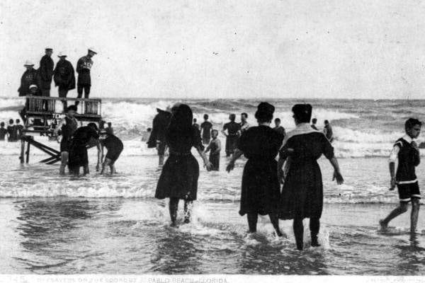 Bathers wading near a lifeguard stand at Pablo Beach, around 1910