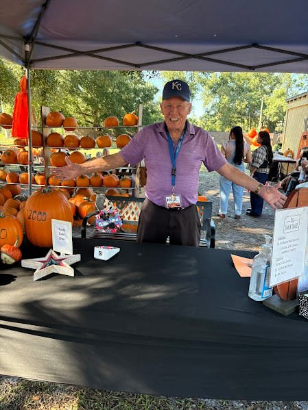 Rich Scott smiling at the pumpkin patch welcome table